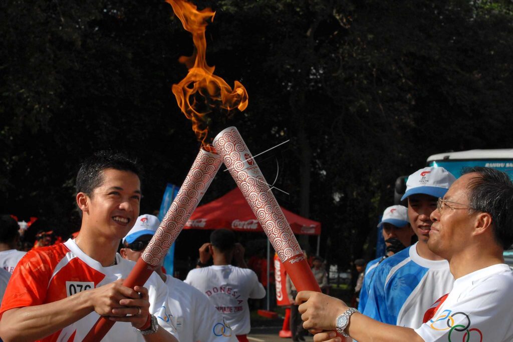 TAUFIK HIDAYAT LIGHTS THE OLYMPIC TORCH